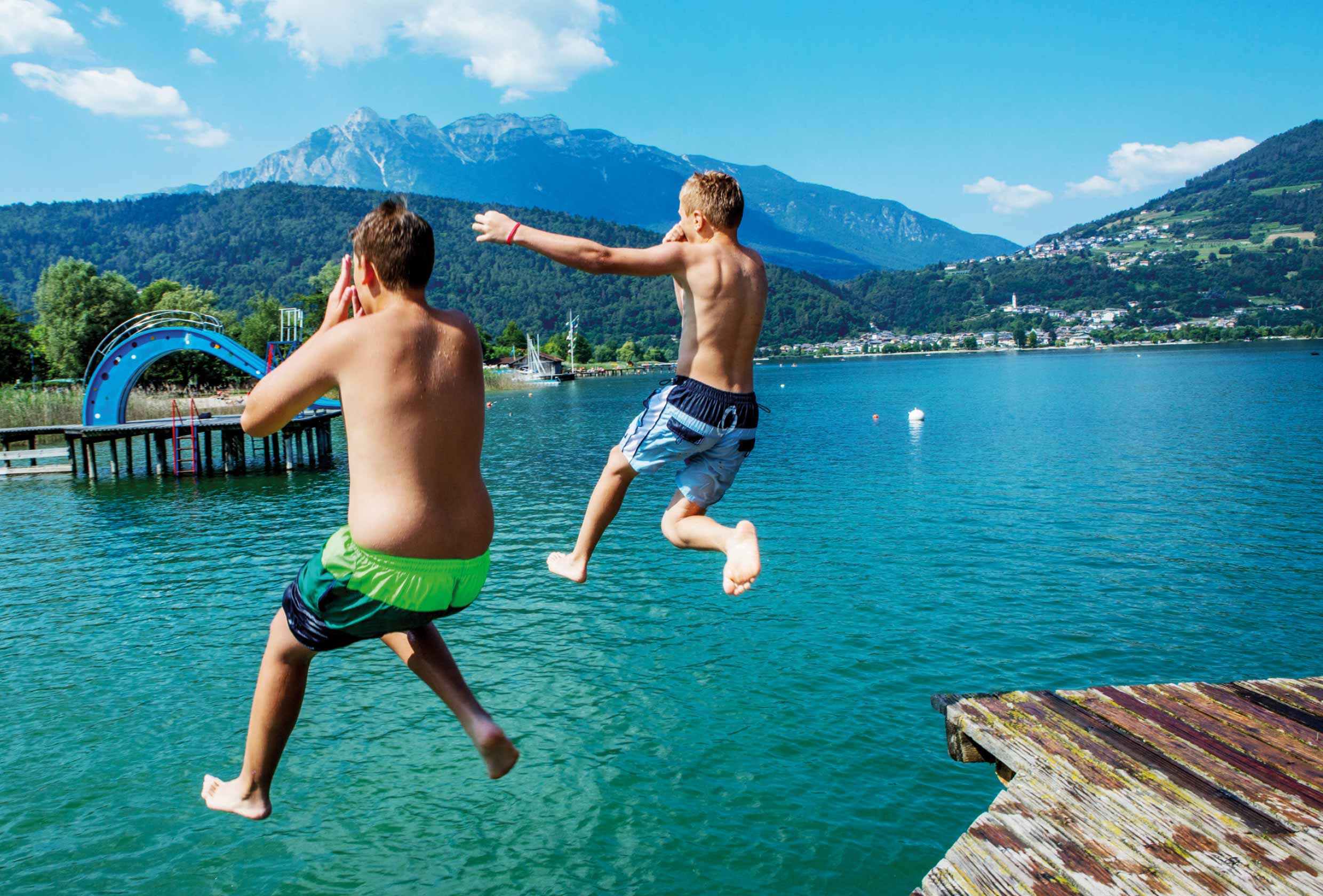 SOS-Feriendorf am Caldonazzo See: Schwimmen, Spass, ins Wasser springen. Kinder im Sommer in der Badehose.